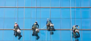 High-rise building team cleaning with rope access